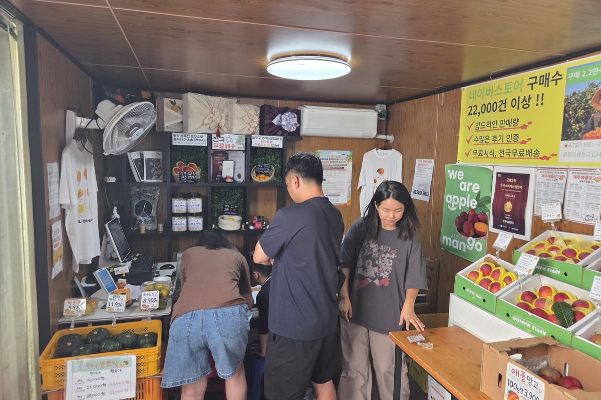 공항길귤창고 매장 내부에서 과일 고르는 사람들