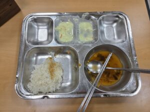 야근한 수요일 저녁 구내식당 식판에 밥이 절반 남은 모습